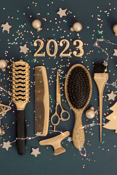 istock Figures 2023 scissors and comb with confetti on dark background. Vertical greeting card of hairdresser or hair salon. 1449021123
