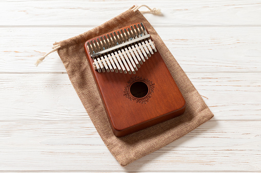 Mbira is African musical instrument. It is a wwoden board with metal tines. Kalimba is modern interpretation of mbira and was produced and popularized outside of Africa.