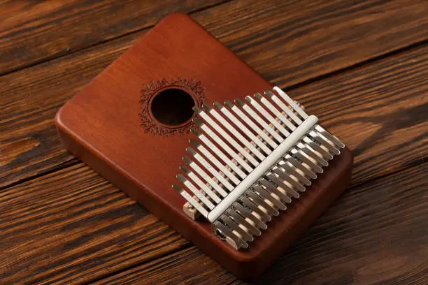 Mbira is African musical instrument. It is a wwoden board with metal tines. Kalimba is modern interpretation of mbira and was produced and popularized outside of Africa.