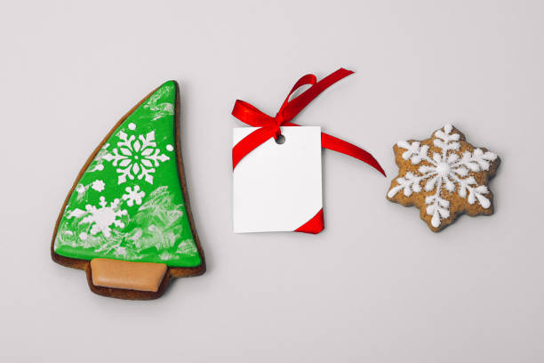 istock gingerbread cookie of Christmas tree and snowflake and white paper for congratulations text on gray background, top view. Close-up. Happy new year and merry christmas concept 1449026813