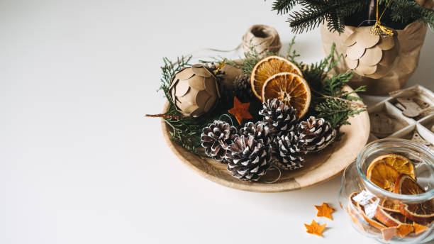 istock Natural Eco friendly Christmas Tree Decorations. Zero waste sustainable Xmas Tree Ornament Hanging Decorations. Christmas Tree and dry orange Slices, snow Christmas Pine Cones Ornament on table 1449030010