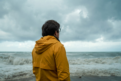 Man on a coastline during stormy weather
