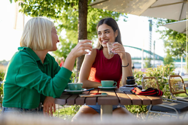 Happy women talking in an outdoor café. stock photo