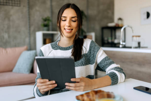 istock Woman using digital tablet at table at home 1449032674