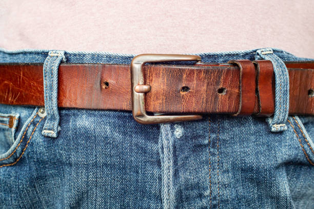 istock Thick brown belt on worn blue jeans 1449032706