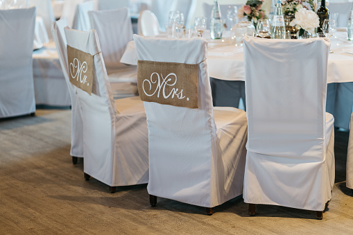 chairs with covers of bride and groom with mr. and mrs. writing at wedding