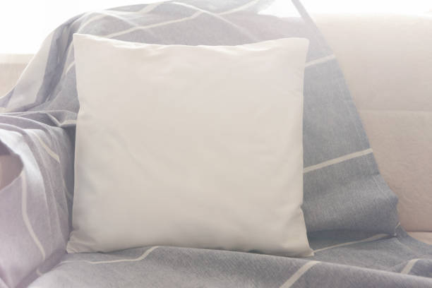 istock Square white pillow on the sofa in bright sunlight. Mockup for design. 1449034445