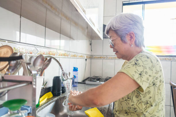 istock Senior woman doing dishes in a domestic kitchen 1449034499