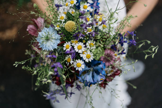 bride holds bridal bouquet with wild flowers