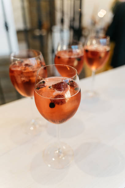 istock pink long drink with wild berries in wine glass 1449036391