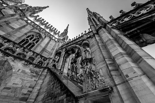A low angle grayscale shot of an exterior of the cathedral of Milan