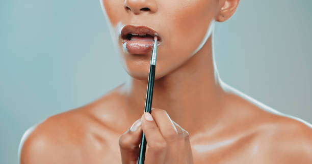 istock Studio shot of beautiful model applying lipstick with brush 1449041946