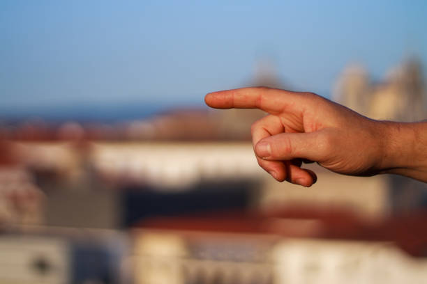 istock Side view of a man's closed hand pointing with his index finger. 1449042198