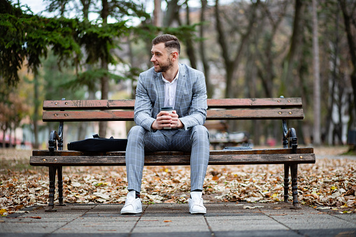 Elegantly dressed businessman reading on a tablet outdoors