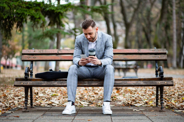 istock Elegantly dressed businessman reading on a tablet outdoors 1449042756