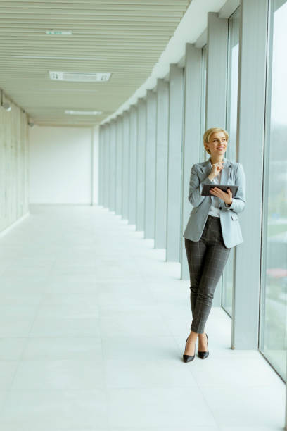 istock Businesswoman using digital tablet on modern office hallway 1449043001