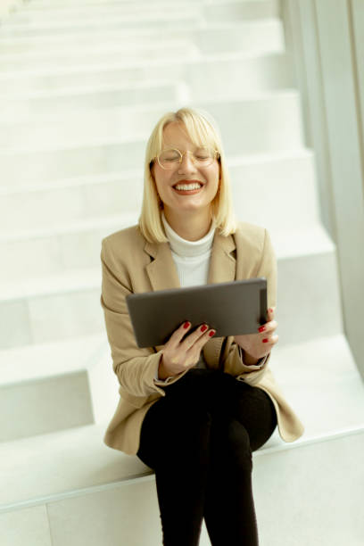 istock Businesswoman with digital tablet on modern office stairs 1449043075