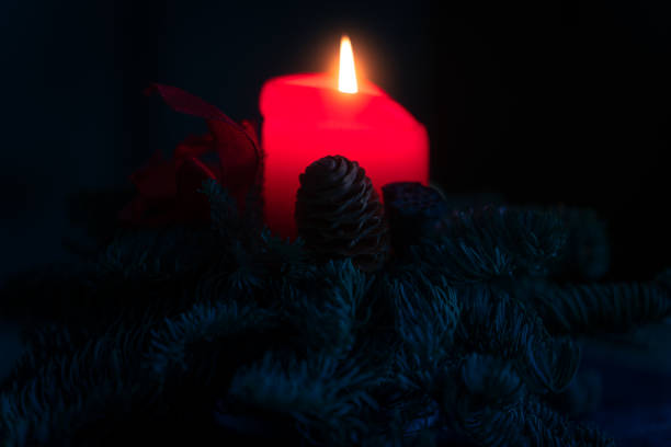 Red candle light Christmas candlelight on glowing flame sparkling green background blurred