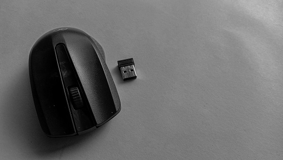 Photo of a wireless mouse with battery and usb next to it on a blue background