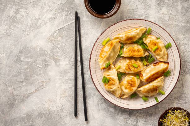 istock Gyoza, japanese pan-fried dumplings, on light background. 1449047079