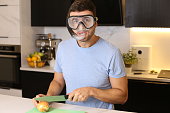 Man protecting his eyes while cutting onions