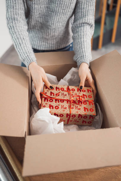 istock Unrecognizable woman packaging a Christmas present to send in the mail 1449062128