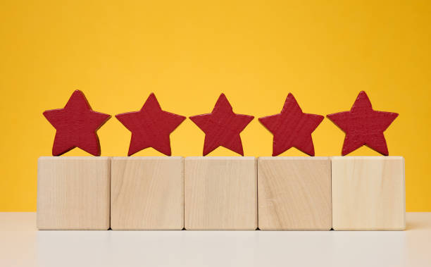 istock Five stars on wooden cubes, yellow background. Service evaluation concept 1449063261