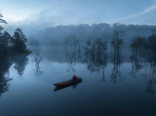 Fisherman in Tuyen Lam lake in a foggy morning, Da Lat city, Lam Dong province, central high lands Vietnam