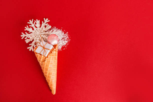 istock Ice Cream Cone with Christmas Decoration snowflake and gift box on red background, greeting card,copy space 1449066144