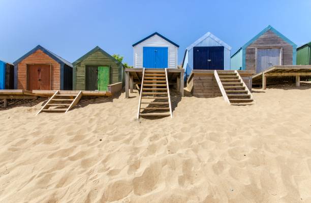 ligne de cabanes de plage sur une plage de sable - north wales photos et images de collection