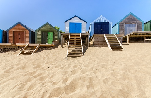 Abersoch, United Kingdom – December 13, 2022: A line of beach huts on a sandy beach