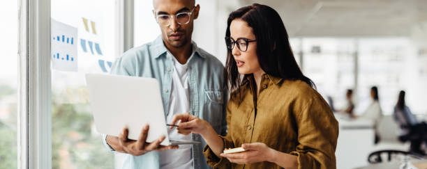 istock Business people standing in an office and using a laptop 1449070081