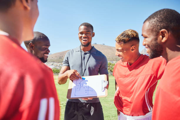 istock Happy soccer coaching, planning strategy and group training of competition game ideas, vision and formation. Football academy players, sports manager and paper skills, goals and sketch of pitch field 1449076213