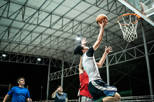 Basketball player makes slam dunk at a basketball court