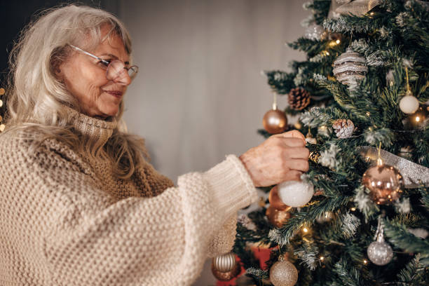 istock Senior woman decorating Christmas tree at home 1449080866