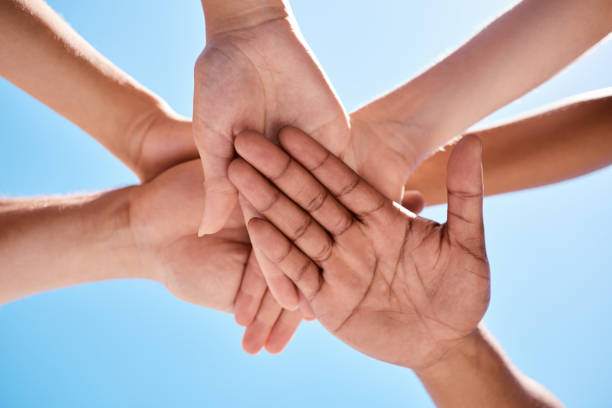 istock Support, community and hands of friends against blue sky for teamwork, collaboration and networking in park. Global, goals and team building with group of people for mission, innovation or motivation 1449081457