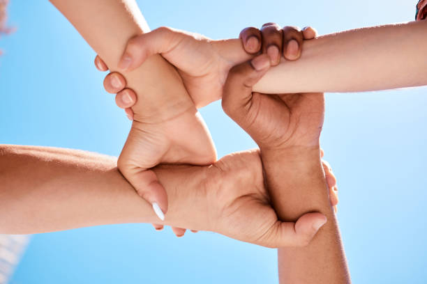 istock Wrist hands, team and community support diversity people, protest group and human rights freedom on blue sky background. Below solidarity, partnership and motivation of goals, trust and world justice 1449081458
