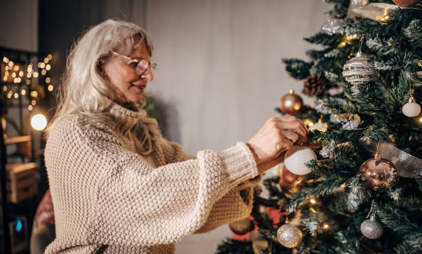 istock Senior woman decorating Christmas tree at home 1449081823