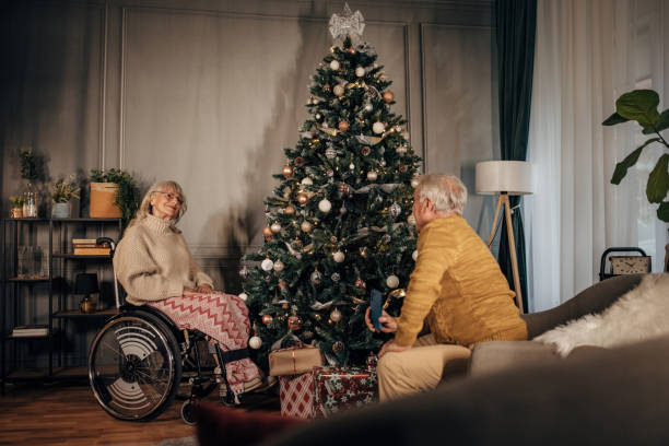 istock Senior couple taking pictures while decorating Christmas tree at home 1449082132