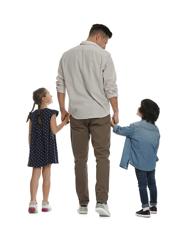 Children with their father on white background, back view
