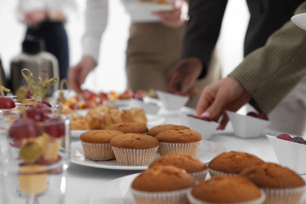 istock People near table with different delicious snacks during coffee break, closeup 1449082493