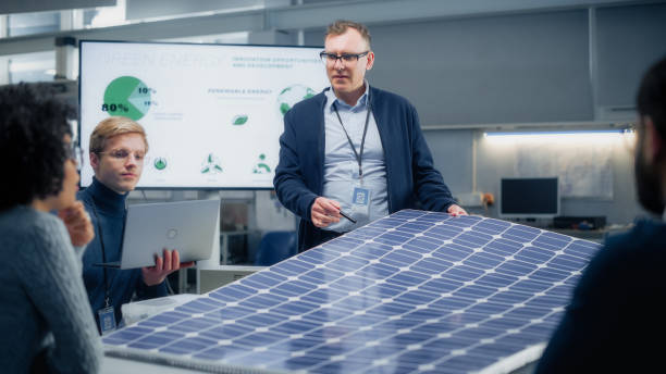 reunión de equipo de ingenieros de energía renovable que trabajan en un concepto innovador de batería de panel solar más eficiente. grupo de especialistas se reunió alrededor de la mesa, resolviendo problemas. centro de investigación brillante. - solar energy solar power station student alternative energy fotografías e imágenes de stock