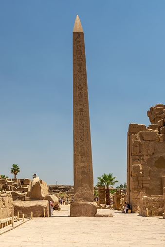 A landscape of stone sculptures in famous Karnak Temple under sunlight and blue sky in Luxor, Egypt