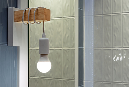 LED lamp with coiled cable in the interior of the bathroom.