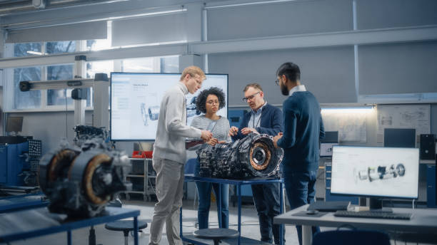 istock Diverse Intelligent Engineers Work Together on Functions Modification of Electric Engine for Innovative Project. Engineering and Sustainable Energy Technologies for Modern Vehicles Concept. 1449084692