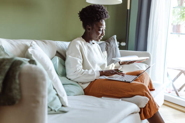 istock Young African-American woman using a laptop and writing notes while attending an online class 1449086266