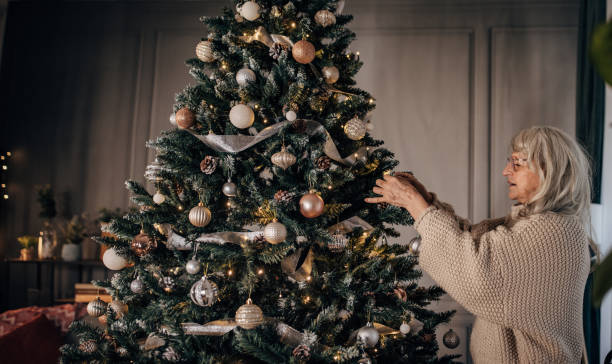 istock Senior woman decorating Christmas tree at home 1449086655