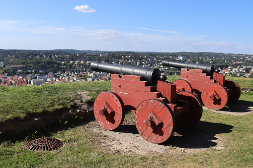 Two historic canons pointed towards Halden city from Fredriksten Fortress in Norway. Copy space above.
