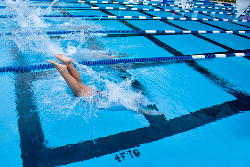 Swimmers racing in a competitive outdoor swim meet.