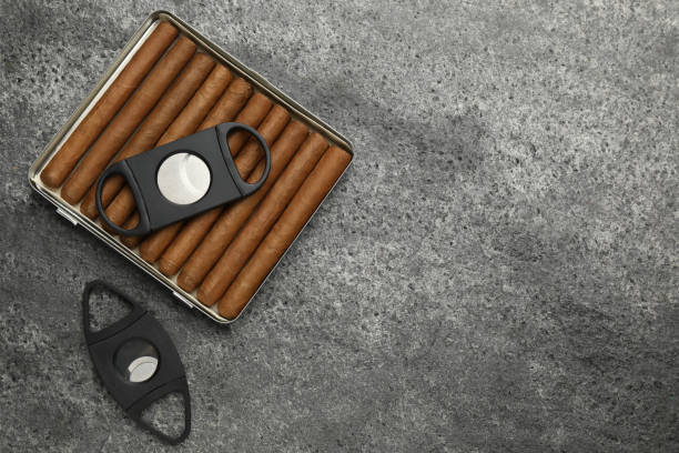 istock Cigars and guillotine cutters on grey table, flat lay. Space for text 1449087465